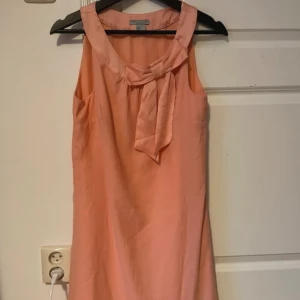 Klänning  - Kort klänning med rosett.