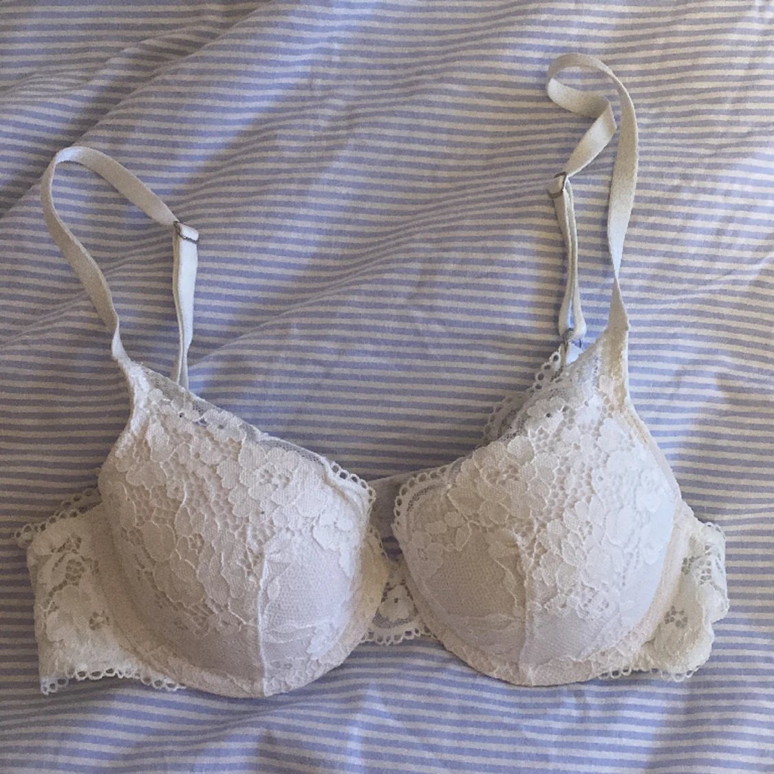 En vitt vaderad spetsig lilja t-shirt bh i storlek 32A. Från Lindex