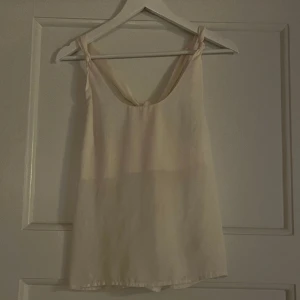 Blus  - CremeVit blus med fin detalj i ryggen. 