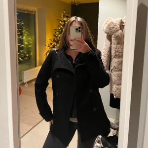 Svart kappa - Denna svarta kappa är kort, men lite tjockare material som passar bra både höst/vinter/vår. Har använt den mycket vid lite finare tillfällen, men den funkar lika bra till skolan. 