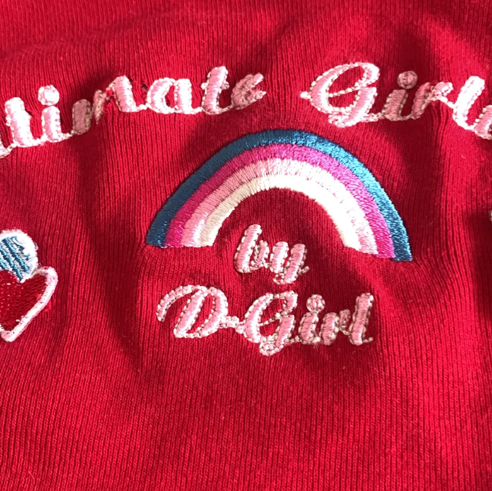 Röd croppad top med tryck på ”ultimate girlwear” väldigt liten i moddellen. . Toppar.