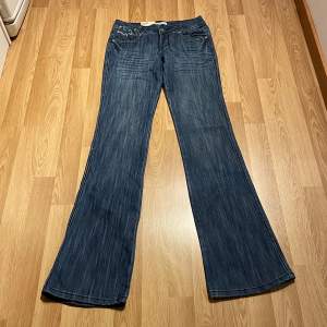 (32) lågmidjade bootcut jeans helt nya med lappar kvar, stretchiga så passar större än måtten, glittriga sömmar. Midjemått rakt över: 32 cm, innerbenslängd: 84cm 🩵