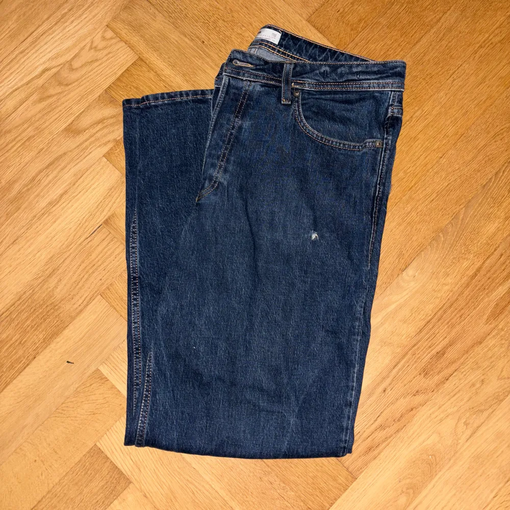 Mörkblåa Jack & Jones jeans, liten defekt under vänster ficka, annars bra skick!😁  Storlek: 33/32. Jeans & Byxor.
