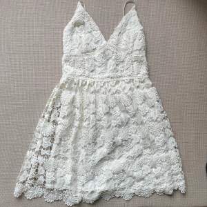 En fin vit klänning med spetsdetaljer och öppen rygg. Aldrig använd, köpt på hollister för några år sedan. Storlek S.