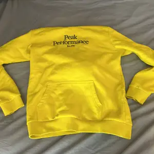 En fin gul peak performance hoodie i storlek 170