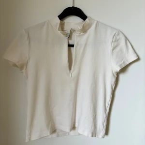 Vit topp - Helt oanvänd topp från Nelly med dragkedja. För fler bilder eller frågor så hör av dig! Köparen står för frakt 📦