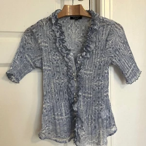 Blus från Kriss Sweden - Mycket fint skick, ser väldigt lyxig ut! Blå och vit mönstrad topp med pärlor som knappar. Nypris på dessa är runt 1000 kr. Storlek Small.