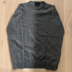 Kashmirtröja - Jättefin kashmirtröja från Strokesman’s i en fet mörkgrå färg. Tröjan är i gott skick, har haft ett hål tidigare i kragen men som blivit lagat väldigt bra, därmed svårt att se (se bild 2). Nypris: 1800. Skriv för frågor eller fler bilder!