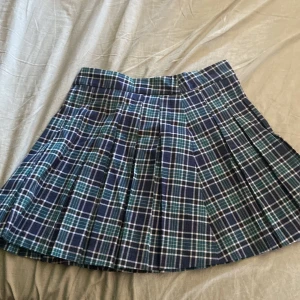 Mörk grön/blå rutig kjol - Mörk grön/blå rutig kjol i bra skick, knappt använd. Storlek M. Går att hämta i Malmö.