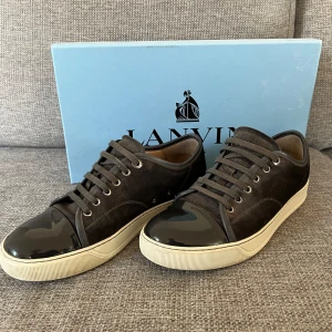 Lanvin skor  - Ett para snygga lanvins i bra skick de är en defekt på de glansiga men annars inget, färgen är dark gray, Dustbag medföljer, pris kan diskuteras!!