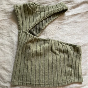 Grön top  - En jätte fin grön top med utklipp. Perfekt för sommar vädret! Materialet är mjukt o topen är i bra skick. 
