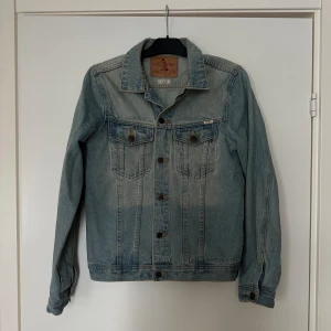 Jeansjacka - En snygg jeansjacka i ”sliten” tvätt från märket Emmett.