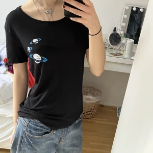 T-shirt med planeter - Cool svart t-shirt med planeter. Tyget faller väldigt fint och är jättemjukt. Köpt second hand men i jättebra skick. Priset kan diskuteras. Frakt tillkommer men kan annars mötas upp vid Medborgarplatsen i Stockholm. 