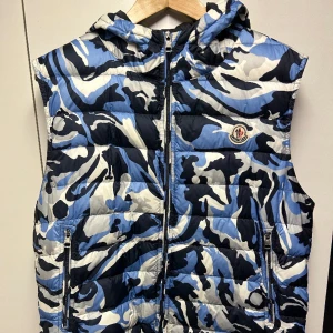 Moncler väst  - Kamouflage moncler väst i jätte bra skick. Finns qr kod i västen. Skriv för fler bilder