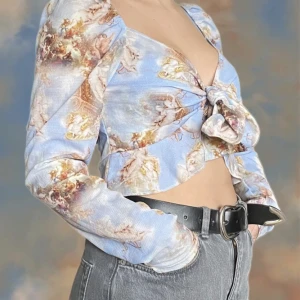 Mönstrad blus i pastellfärger  - Superfin blus med rokoko motiv. Går att knyta på olika sätt. I princip ny