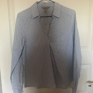 Blå fin skjorta me svarta prickar  - En blå finskjorta me svarta prickar från H&M. Använd kanske en gång för 2 år sedan men har aldrig riktigt kommit till användning. Ny skick och inga fläckar. Köpare står för frakt!!