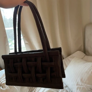 Väska  - Mörkbrun flätad väska. Använd fåtal gånger, därav nyskick. 