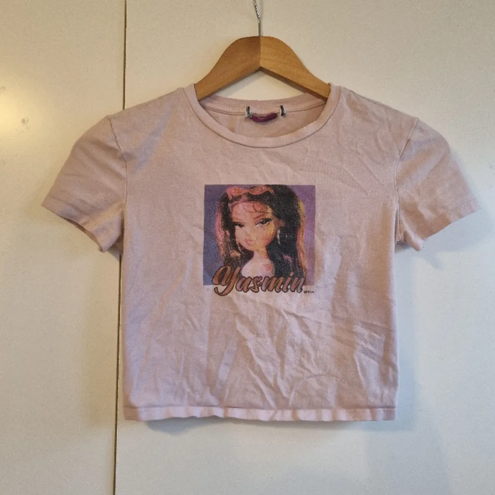 Säljer denna baby tee /croppad t-shirt med Bratz motiv💓 Använd men i bra skick💓 Säljer för 50kr + frakt🩷. T-shirts.