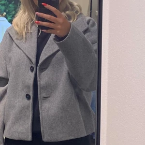 Grå vårkappa  - Jättefin grå vårkappa från VeroModa. Säljer den då den inte kommit till användning så mycket. Använd kanske 5 gånger så är som i nyskick. Köpte den för 700kr. 