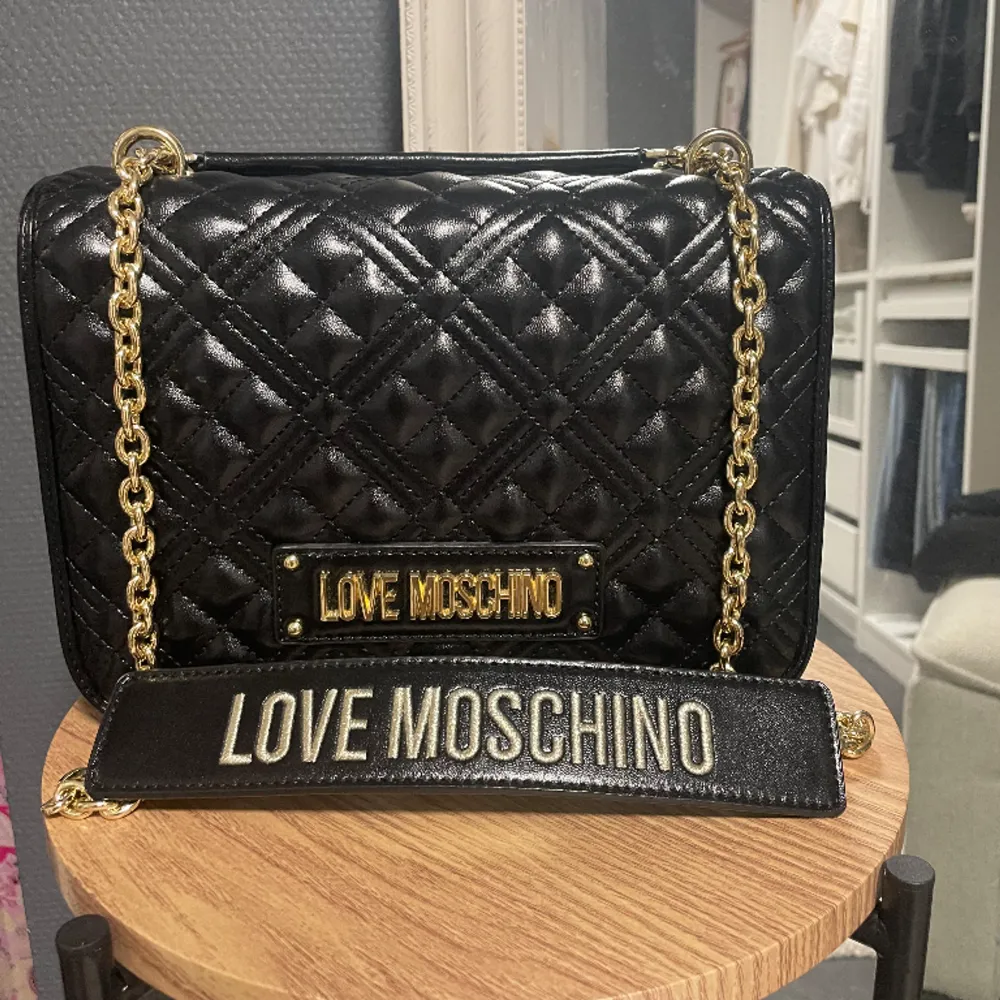 Helt oanvänd Moschino väska! Längd: 33 cm Höjd: 23,5  Djup: 12, 5 cm . Det finns tre fack och en med dragkedja. Väskan stängs med magnet knapp 🥰🥰 Köpt för ca 3000kr . Väskor.