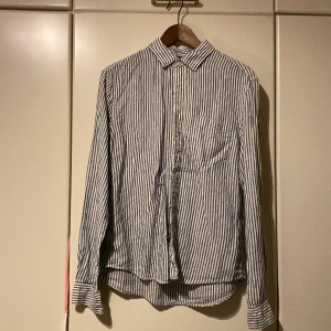 Linne skjorta från Arket - En blå randig linneskjorta från arket. Använd en enstaka gång och i mycket bra skick