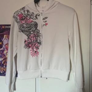 Vit tröja - En vit tröja med rosa detaljer som aldrig kommit till användning. Köpt här på plick. Samfraktar gärna med andra saker! 