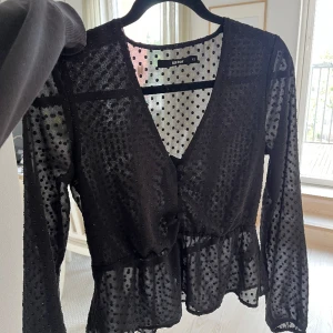 Svart blus - Svart blus från Bik Bok. Jättefin!!!! En ögla till en knapp där fram som har försvunnit men annars är det ingen defekt. 