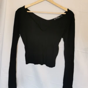 Svart långärmad  - Svart långärmad med V-cut framtill. Perfekt som pasblagg! 