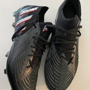 Adidas fotbollsskor  - Bra skick. Storlek 41 1/3. Använda 2 månader. Nypris 2349:- Väldigt skönt och bra fotbollssko. Länk till produkt: https://www.intersport.se/skor/fotbollsskor/konstgrasskor/adidas-predator-edge1-l-fg-fotbollsskor/cblack-ftwwht-vivred