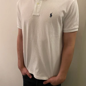 Tröja Polo Piké - Vit tröja från Ralph Lauren. Tröjan är använd en eller två gånger för ett ungefär år sedan, och har legat i garderoben sen dess. Anledningen till att tröjan inte använts mer, är att den är för stor för mig. 