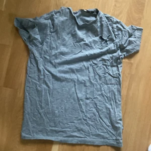 Puma T-shirt - En grå puma t-shirt i fint skick! Använd utan skador och knappast några tecken på användning. Säljer för att bli av med!