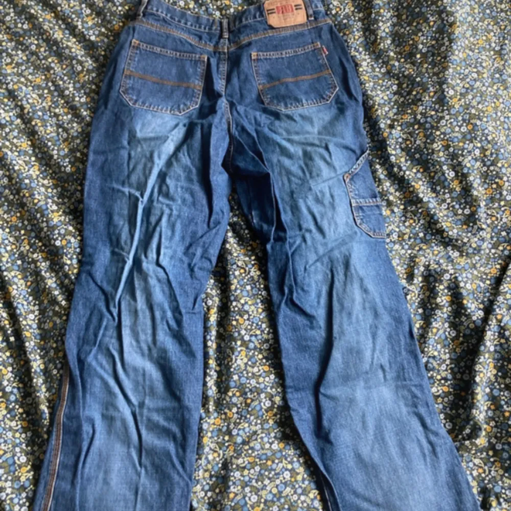 straight leg högmidjade jeans från märket rainbow med coola detaljer på benen. W27 storlek 44, står i byxorna. . Jeans & Byxor.
