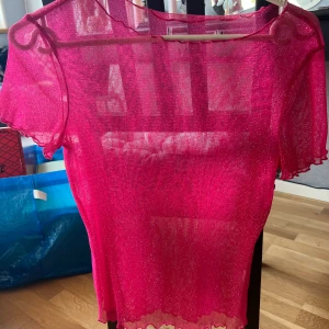 Glittrig rosa genomskinlig Tshirt - Använd bara 1 gång på nyår, i gott skick. Stretchigt material. 