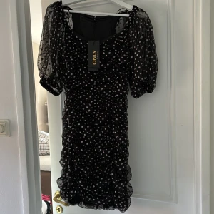 Klänning  - Så himla fin klänning, i svart när och med guldiga detaljer🔥🌸 OANVÄND, lappen kvar. Orginalpris är 500 kronor.