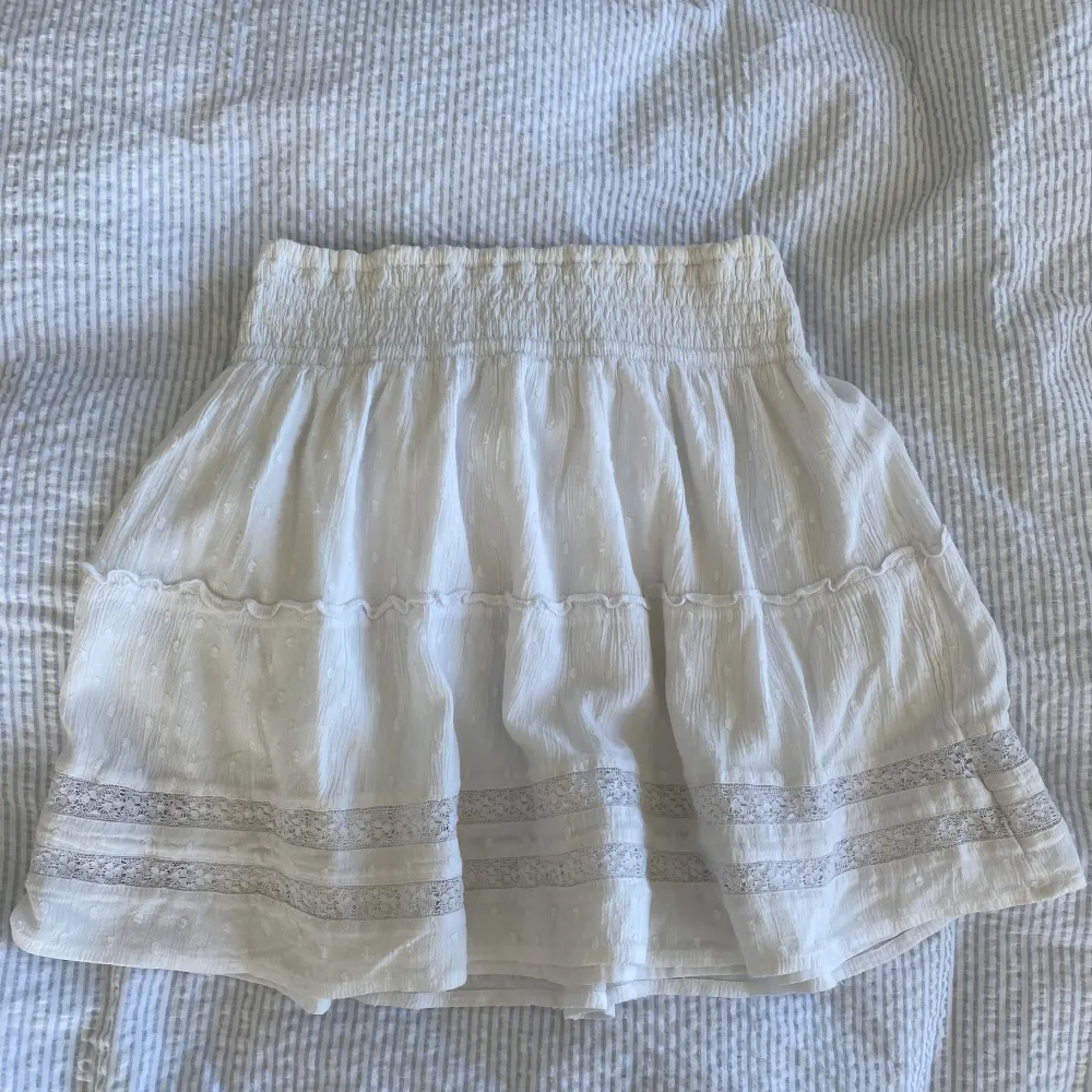 Superfin vit kort kjol från Hollister med broderidetaljer. Underkjol finns så den är inte genomskinlig! Liten antydan till missfärgning högst upp av solkräm💗. Kjolar.