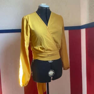 Knytblus - Fin och skön gul knytblus. Går att knyta snörena både bak och fram.