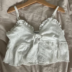 Vit somrig topp  - Vit topp, perfekt för sommaren med gulliga detaljer🤍 Den är i storlek S men jag skulle mer säga att det är XS. Den är verkligen super fin men den passar inte mig🤍🤍