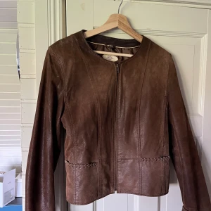 Läderjacka  - Brun jacka i läder från märket JofaMa. Fina detaljer vid ärmen och fickorna.  Strl 42 men ganska liten, 400kr men kan diskutera priset. Frakt står köparen för💕  Ps, Klänningen på bilderna är också till salu i min profil😊