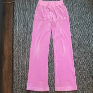 Jag säljer ett par rosa juicy byxor. - Nästan aldrig andvända lite smutsig vid byxbenet.En av dom silvriga på snöret är löst.