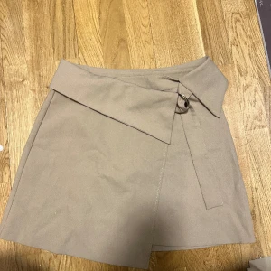 Kjol från zara  - Beige kjol från zara, knappt använd storlek M.  Färgen på kjolen är mest lik den i mitten, alltså den andra bilden! 