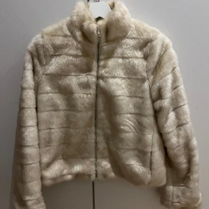 Jacka i fuskpäls - Jättefin jacka i fuskpäls. Den har en liten fläck(se bild) men är i övrigt i fint skick :) 