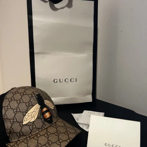 Gucci keps  - Gucci keps i väldigt bra skick. Säljs inte längre i butik och är sparsamt använd. Allt på bilden medkommer. Kvitto finns som äkthetsbevis. Har ni frågor så ställ dom 