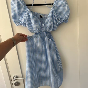 Sommarklänning  - Härlig kort sommarklänning med öppningar på sidan av magen. Sitter jätte fint på och är stretchig. Är storlek 40 men är som en 38.  