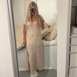 Klänning - Blommig långklänning med slits på benet Finns dragkedja på sidan