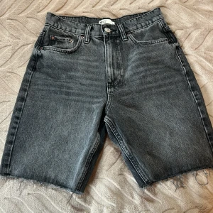 Långa shorts - Ett par längre jeansshorts från Gina tricot. I färgen svart/mörkgrå. Ej använda alls. Storlek 34