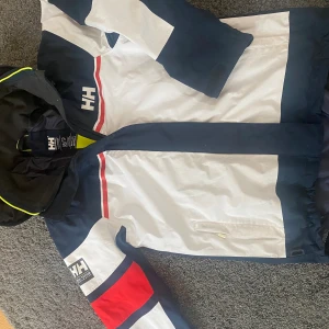 Helly Hansen Vind/regnjacka - Säljer denna helly Hansen vindjackan men som också fungerar som regnjacka. Den är i bra skick och inga skador som påverkar skicket och användandet, bara lite smuts som inte går att få bort efter tvätt.