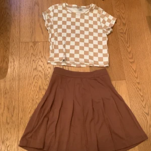 Kjol + T-shirt💗 - Matchande sett från Lindex storlek 134/140 på kjolen (oanvänd) och 146/152 på tröjan. Färg: brun/beige. 
