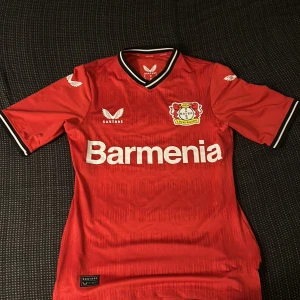 Bayern leverkusen t shirt äkta  - Jag säljer en Bayern leverkusen tröja som är äkta. Tröjan är splitterny och är inte använd. Ställ om ni har några frågor!