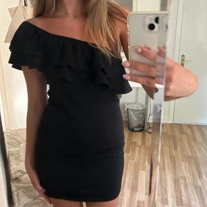 Svart volangklänning  - Jättefin klänning med volang🖤 kan ha både off-shoulder och one-shoulder!