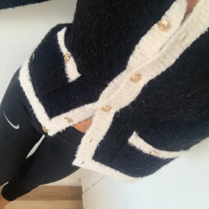 Kofta med guld knappar  - En stickad kofta med guld knappar 